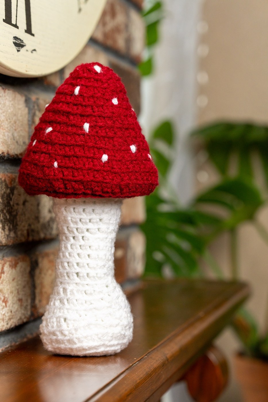Full crochet mushroom indoors with plant background